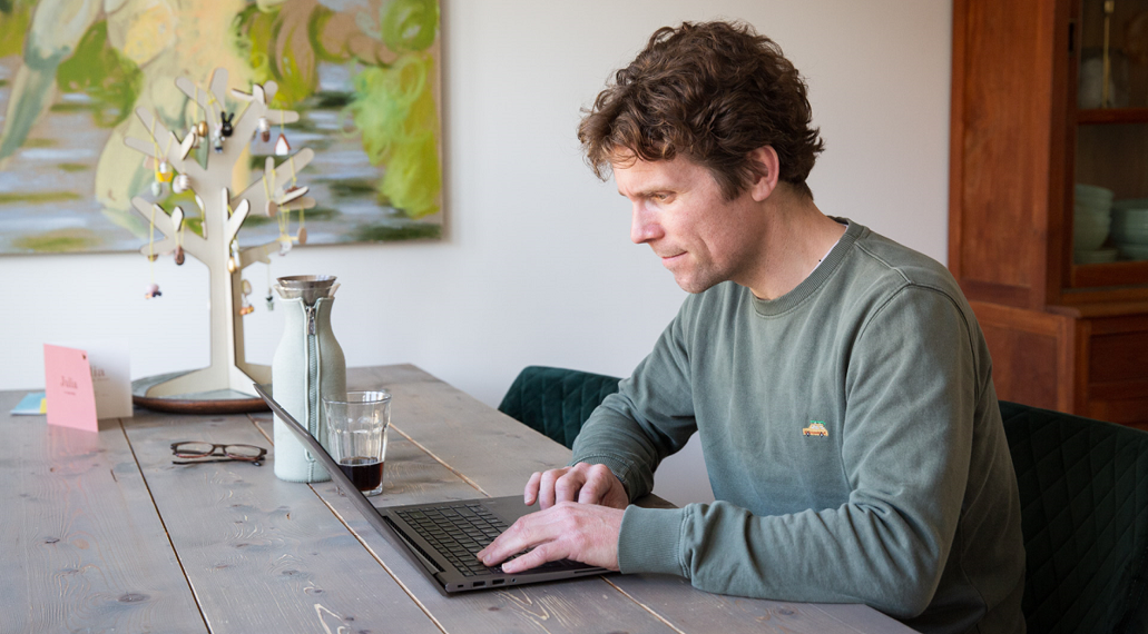 Een man zoekt iets op op het internet.