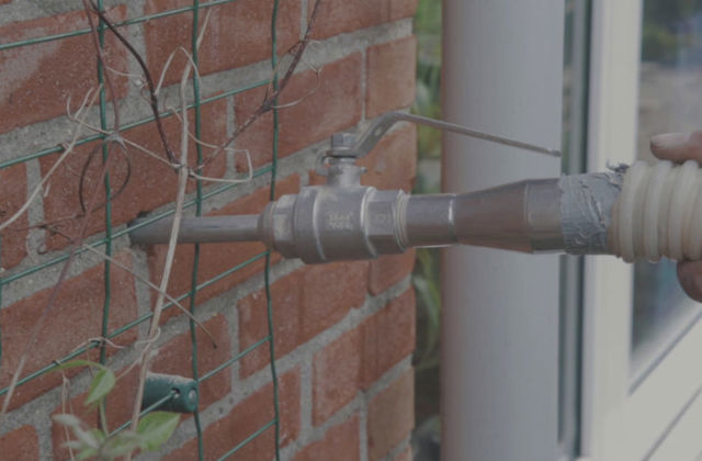 Spouwmuurisolatie. Met een slang wordt het isolatiemateriaal in de muur gespoten.