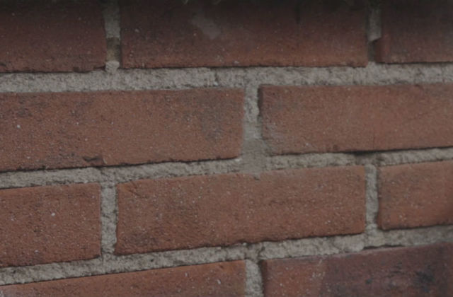 Spouwmuurisolatie. Na het isoleren worden de gaten in de muur met cement opgevuld.