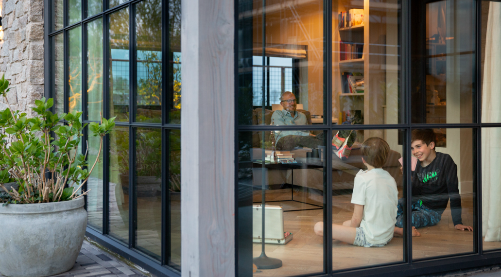 Twee jongens zitten op de vloer en spelen een kaartspelletje. Een goed geïsoleerd huis is comfortabel en energiezuinig.