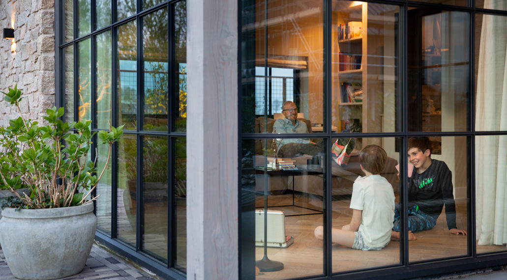 Twee jongens zitten op de vloer en spelen een kaartspelletje. Een goed geïsoleerd huis is comfortabel en energiezuinig.