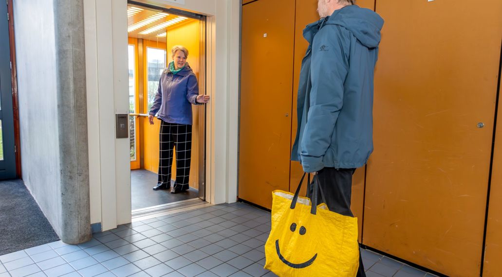 Iemand houdt de lift vast voor een ander.