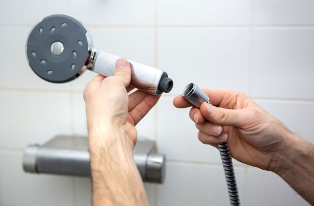 Hand met waterbesparende douchekop