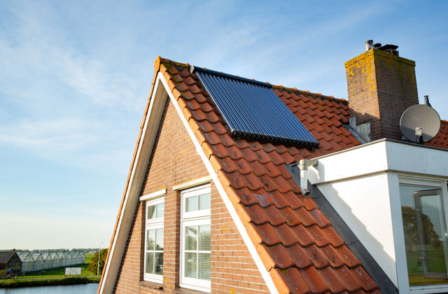 Zonneboiler op dak van een huis.