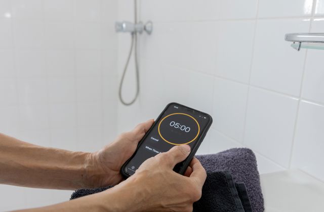 Iemand stelt de timer op de telefoon in op 5 minuten.