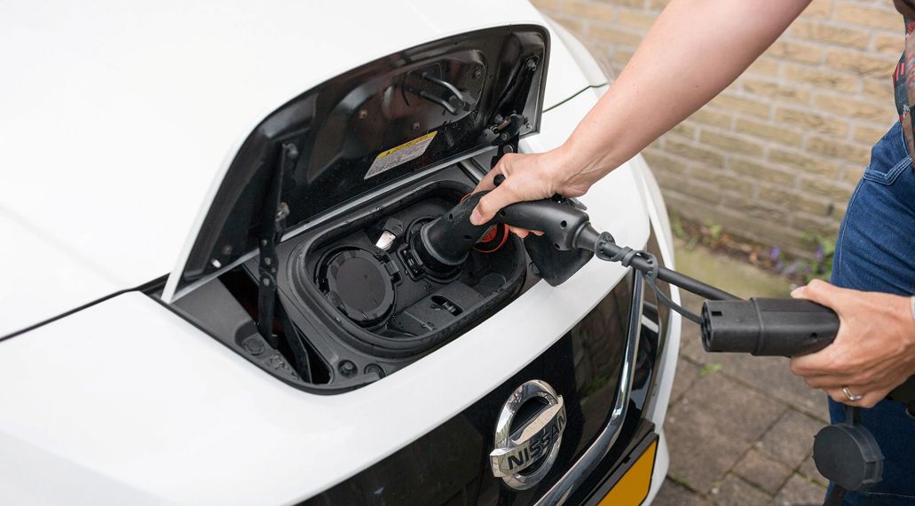Iemand laadt haar elektrische auto op.