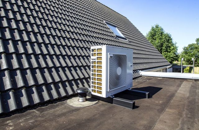 Buitenunit van een hybride warmtepomp op een plat dak.