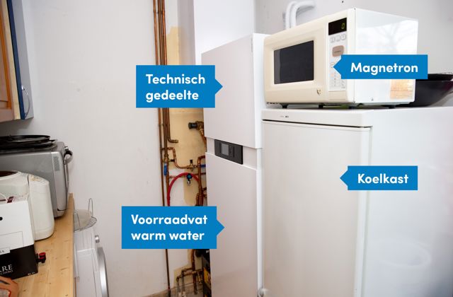 Warmtepomp staat in de bijkeuken, naast de koelkast en magnetron