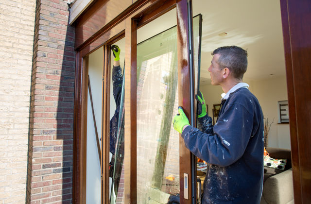 Medewerkers glasbedrijf plaatsen HR++ glas in de kozijnen.