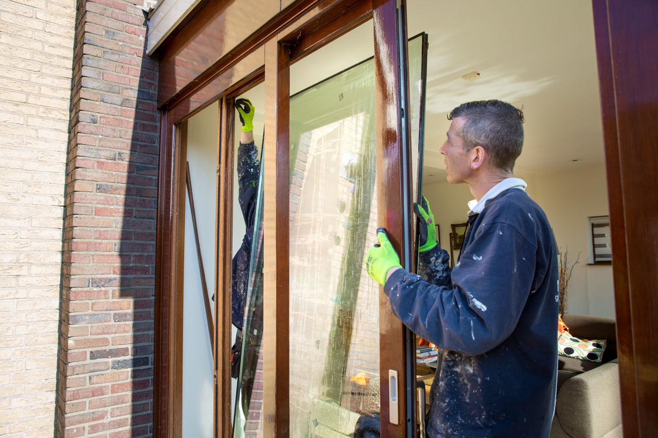 Medewerkers glasbedrijf plaatsen HR++ glas in de kozijnen.